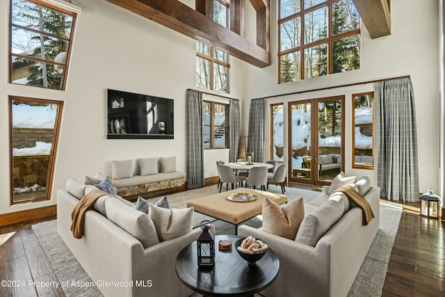 living room with dark hardwood / wood-style floors, beam ceiling, a high ceiling, and french doors