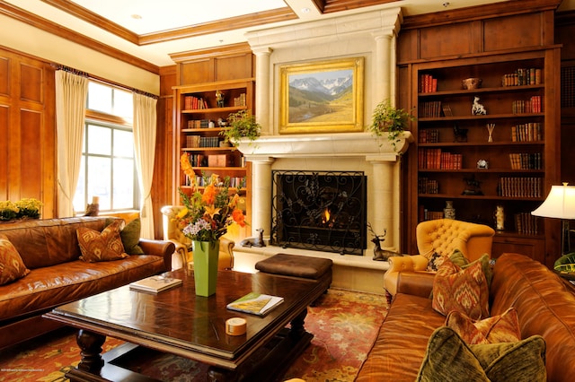 living area with crown molding, a warm lit fireplace, and built in shelves