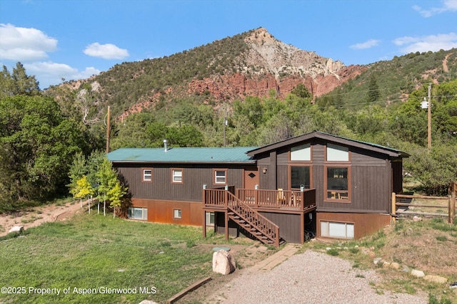 116 S Bill Creek Rd, Carbondale, CO 81623 - view of front of home with stairway, gravel driveway, a deck with mountain view, an attached garage, and a metal roof