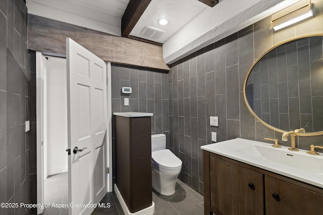 116 S Bill Creek Rd, Carbondale, CO 81623 - half bathroom with tile walls, vanity, beam ceiling, and tile patterned floors