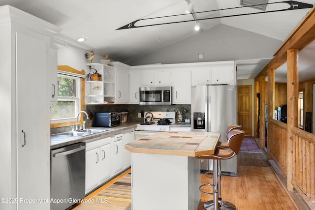 116 S Bill Creek Rd, Carbondale, CO 81623 - kitchen featuring appliances with stainless steel finishes, tile countertops, lofted ceiling, a kitchen island, and light wood-style floors
