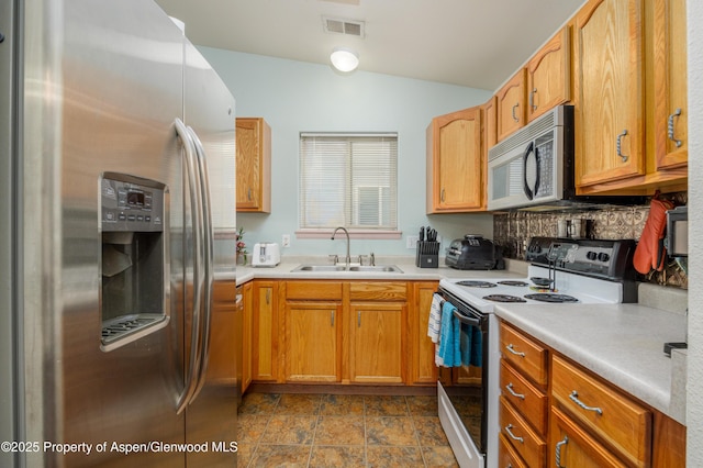 473 Robin Ct, Grand Junction, CO 81504 - kitchen with appliances with stainless steel finishes, lofted ceiling, tasteful backsplash, light countertops, and dark stone finish flooring