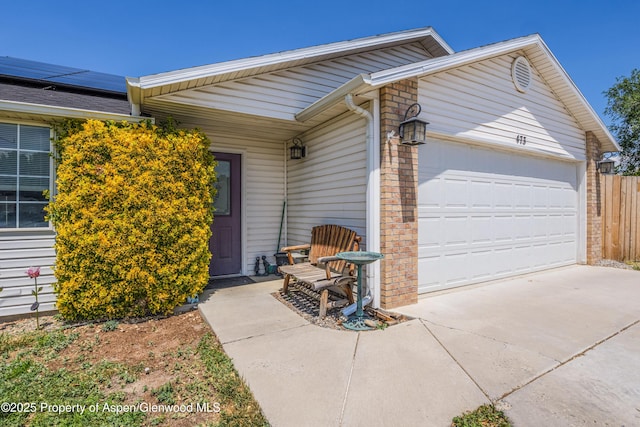 473 Robin Ct, Grand Junction, CO 81504 - doorway to property featuring a garage, roof mounted solar panels, and driveway