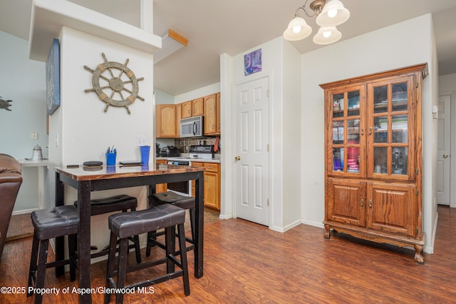 473 Robin Ct, Grand Junction, CO 81504 - dining area featuring dark wood-style flooring, a chandelier, and vaulted ceiling