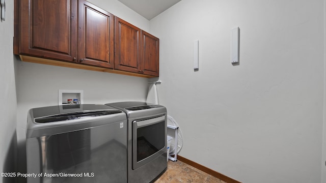 washroom with cabinets and washing machine and clothes dryer