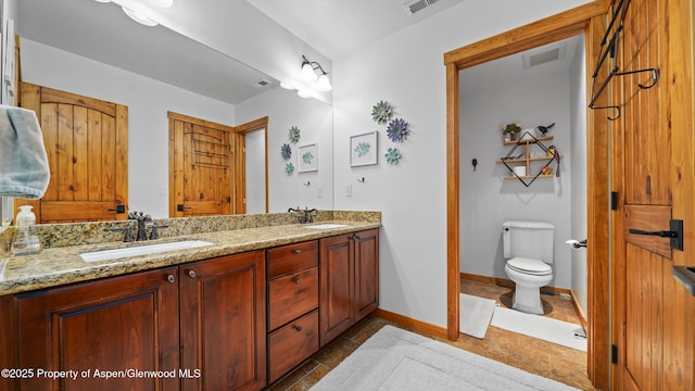 bathroom featuring vanity, tile patterned floors, and toilet