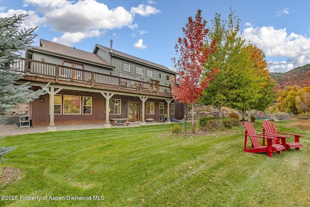 back of house with a patio area, a lawn, and a deck