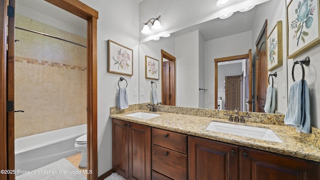 full bathroom with vanity, tiled shower / bath combo, and toilet