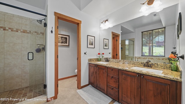 bathroom with vanity, toilet, tile patterned flooring, and a shower with door