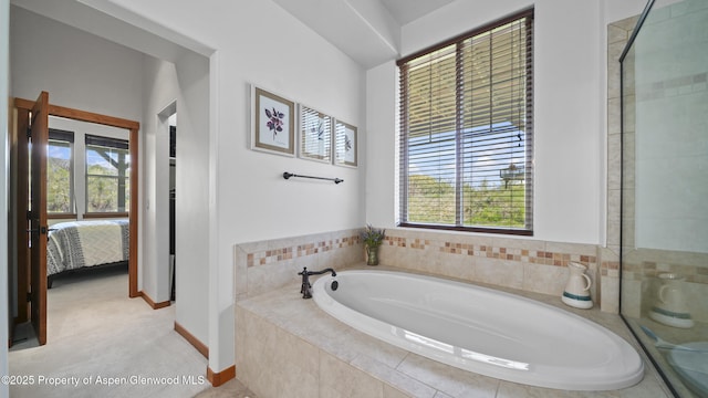 bathroom with shower with separate bathtub and a healthy amount of sunlight