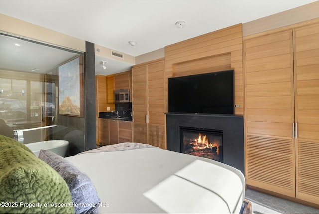 bedroom featuring visible vents and a large fireplace