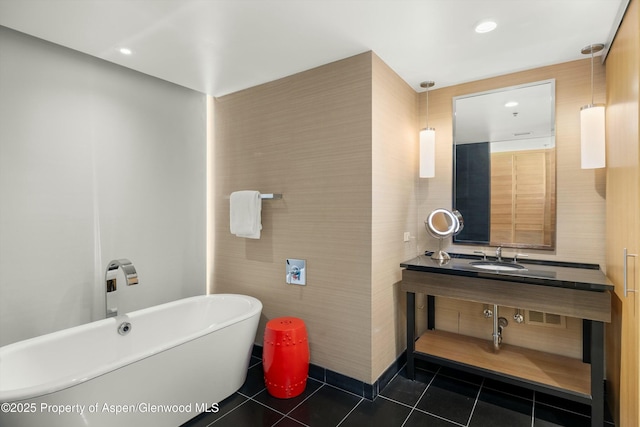 bathroom featuring a sink, a freestanding bath, recessed lighting, and tile patterned flooring