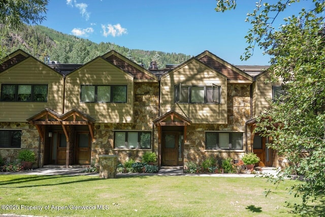 625 S W End St Unit 12, Aspen, CO 81611 - view of front of home featuring stone siding, a front lawn, and a mountain view