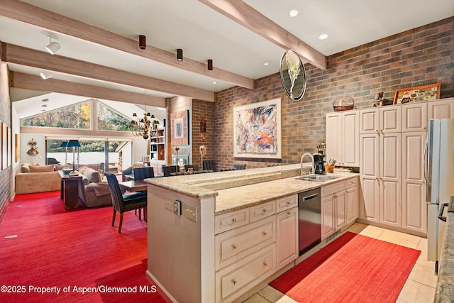 625 S W End St Unit 12, Aspen, CO 81611 - kitchen with open floor plan, stainless steel appliances, light stone counters, cream cabinets, and brick wall