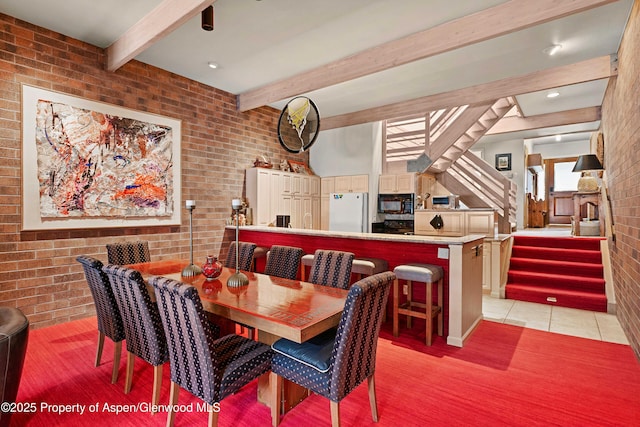 625 S W End St Unit 12, Aspen, CO 81611 - dining space with brick wall, beamed ceiling, stairs, and light tile patterned floors