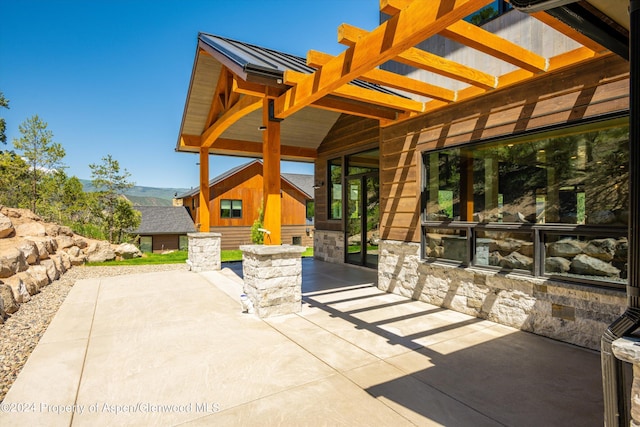 view of patio with a pergola and an outbuilding