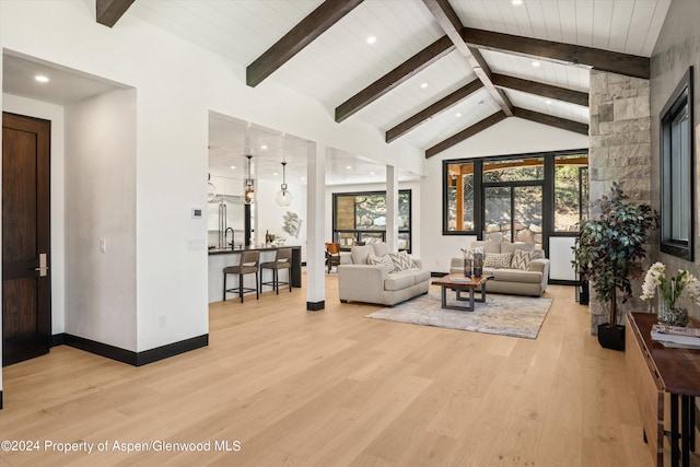 living room with high vaulted ceiling, french doors, sink, light hardwood / wood-style flooring, and beamed ceiling