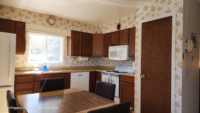 936 Legion St, Craig, CO 81625 - kitchen featuring light countertops, decorative backsplash, wallpapered walls, and white appliances