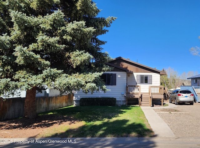 936 Legion St, Craig, CO 81625 - view of front of property with a front lawn, fence, and a wooden deck