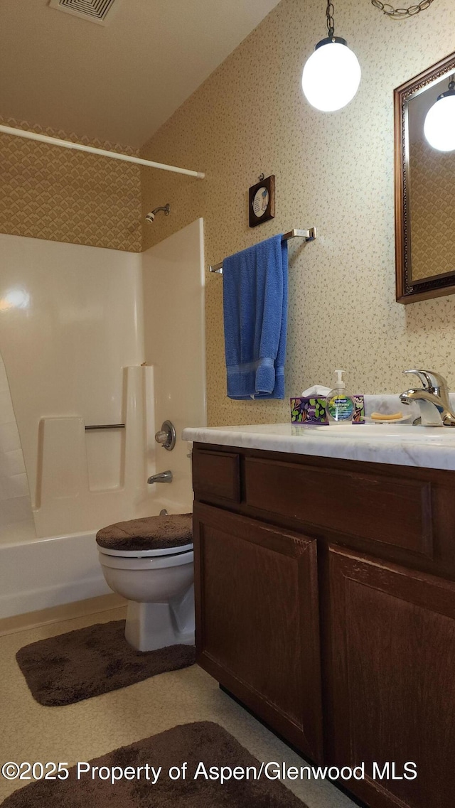 936 Legion St, Craig, CO 81625 - bathroom with shower / bathing tub combination, visible vents, vanity, toilet, and wallpapered walls