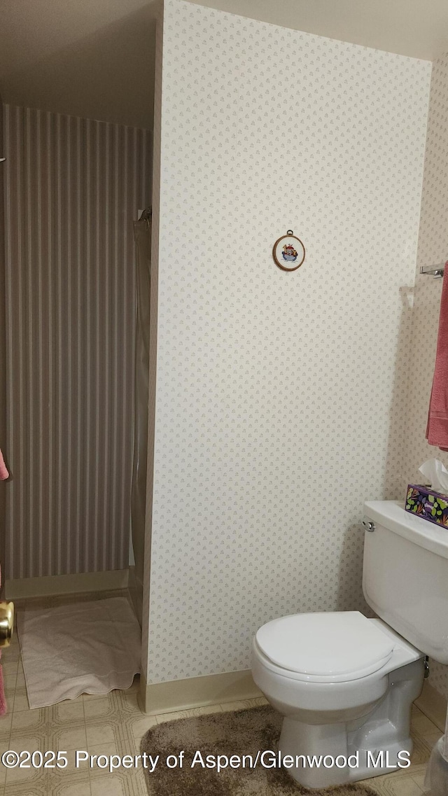 936 Legion St, Craig, CO 81625 - bathroom with toilet, tile patterned floors, wallpapered walls, and a shower