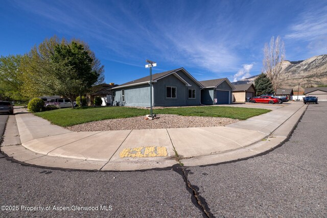165 Harris Ln, Parachute, CO 81635 - single story home with a front yard, concrete driveway, an attached garage, and stucco siding