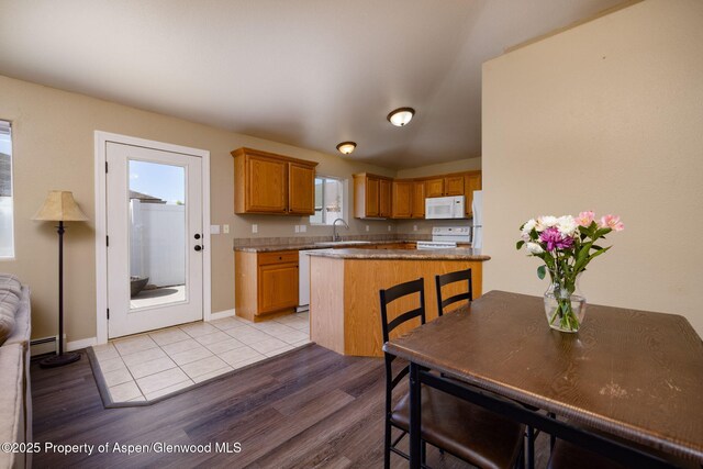 165 Harris Ln, Parachute, CO 81635 - kitchen featuring white appliances, light wood-style floors, a baseboard radiator, and brown cabinetry