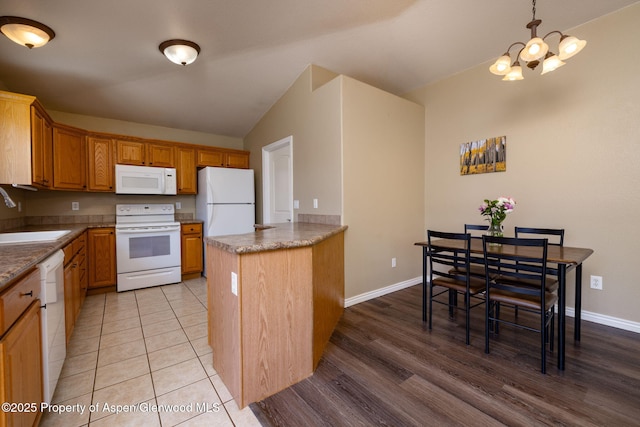 165 Harris Ln, Parachute, CO 81635 - kitchen featuring white appliances, a chandelier, a peninsula, light wood finished floors, and hanging light fixtures