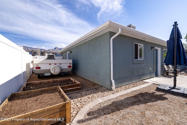 165 Harris Ln, Parachute, CO 81635 - view of home's exterior featuring a vegetable garden, a patio, and a fenced backyard