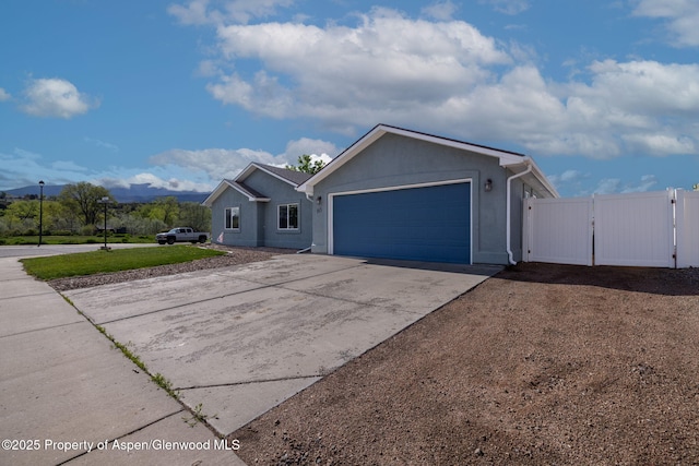 165 Harris Ln, Parachute, CO 81635 - view of front of property with a gate, an attached garage, driveway, and stucco siding