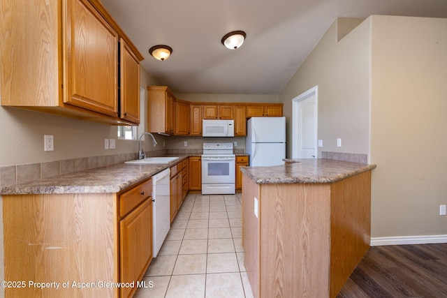 165 Harris Ln, Parachute, CO 81635 - kitchen featuring white appliances, a peninsula, light countertops, and lofted ceiling