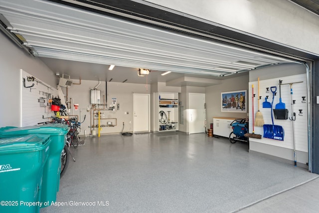 garage with water heater and a garage door opener