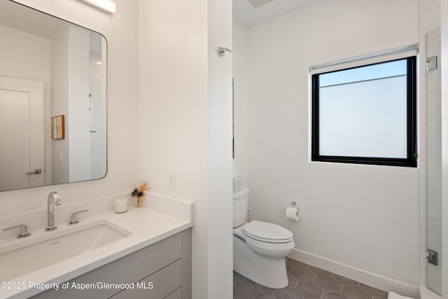 full bath with tile patterned flooring, baseboards, toilet, vanity, and a shower