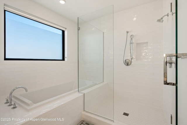 bathroom featuring a tile shower and a garden tub