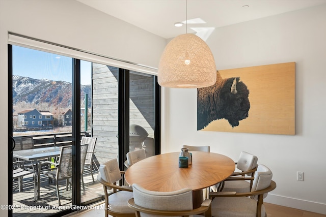 dining area with a mountain view, baseboards, and wood finished floors