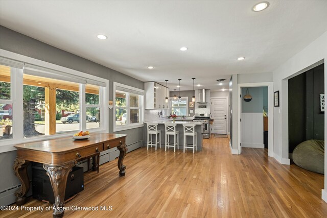 341 Park Dr, Glenwood Springs, CO 81601 - kitchen with a peninsula, white cabinetry, a breakfast bar, stainless steel range with gas stovetop, and light countertops