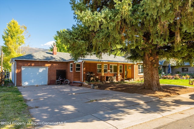 341 Park Dr, Glenwood Springs, CO 81601 - ranch-style home with driveway, an attached garage, brick siding, and a chimney