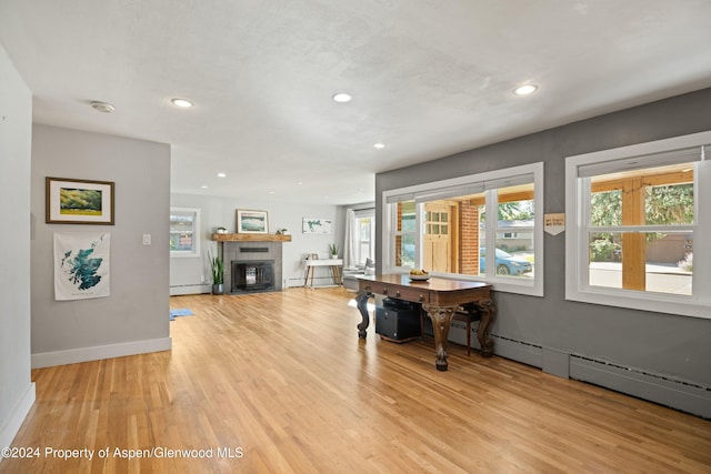 341 Park Dr, Glenwood Springs, CO 81601 - living room featuring light wood finished floors, recessed lighting, a glass covered fireplace, and a baseboard heating unit