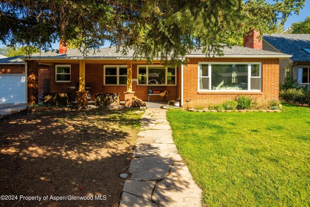 341 Park Dr, Glenwood Springs, CO 81601 - ranch-style house with brick siding, a chimney, a front lawn, and an attached garage