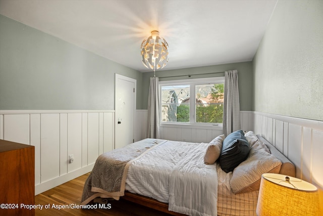 341 Park Dr, Glenwood Springs, CO 81601 - bedroom with wood finished floors, a chandelier, and wainscoting