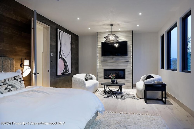 bedroom featuring a large fireplace and light hardwood / wood-style floors