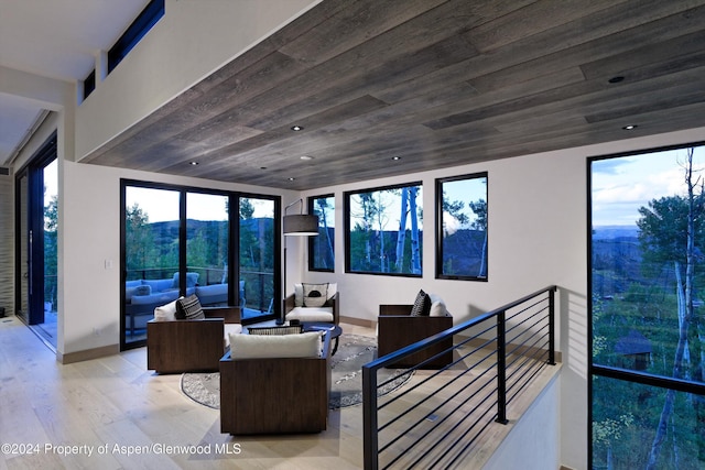 living room featuring light wood-type flooring and wood ceiling