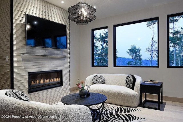 living room featuring hardwood / wood-style flooring, a fireplace, and a chandelier