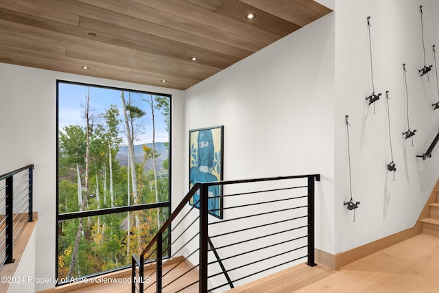 staircase featuring a mountain view, wooden ceiling, and hardwood / wood-style flooring