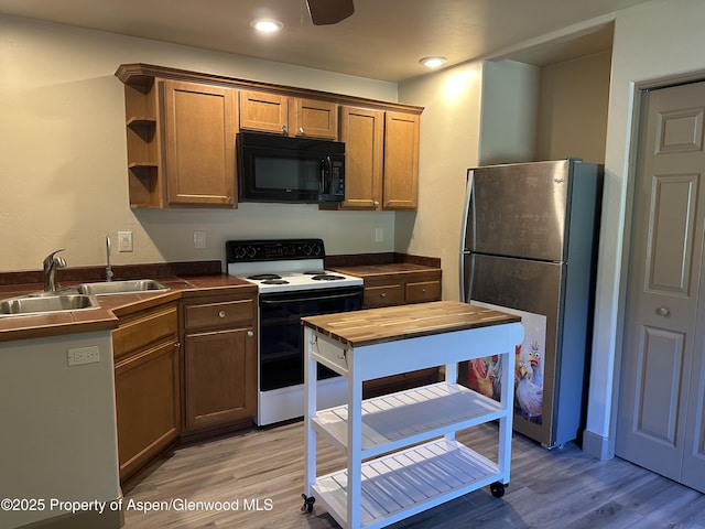 1913 Colorow Rd, Glenwood Springs, CO 81601 - kitchen featuring black microwave, freestanding refrigerator, white range with electric cooktop, dark countertops, and light wood-type flooring