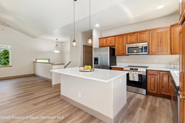 1913 Colorow Rd, Glenwood Springs, CO 81601 - kitchen featuring appliances with stainless steel finishes, light wood-style floors, brown cabinetry, light countertops, and vaulted ceiling