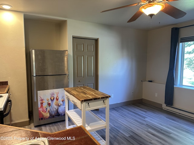 1913 Colorow Rd, Glenwood Springs, CO 81601 - kitchen with freestanding refrigerator, stove, wood finished floors, a ceiling fan, and a baseboard radiator