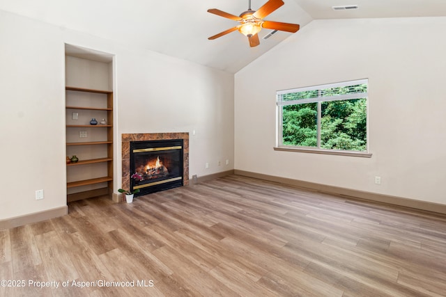 1913 Colorow Rd, Glenwood Springs, CO 81601 - unfurnished living room featuring ceiling fan, a tile fireplace, vaulted ceiling, wood finished floors, and built in features