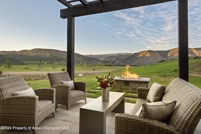 view of patio / terrace with a rural view, a mountain view, and a fire pit