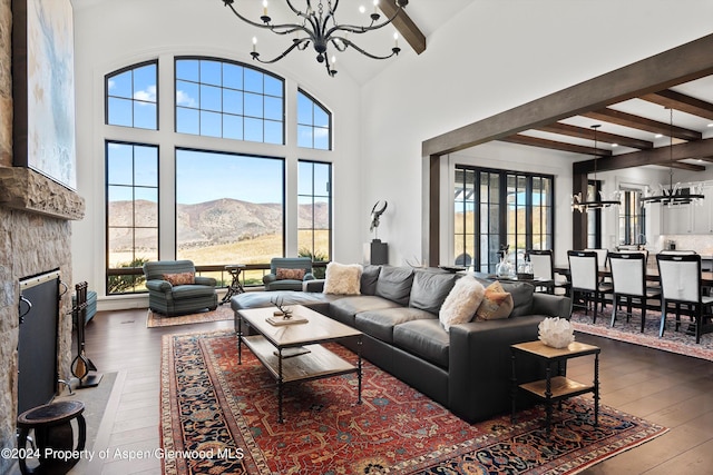 living room with wood finished floors, a mountain view, a stone fireplace, and an inviting chandelier